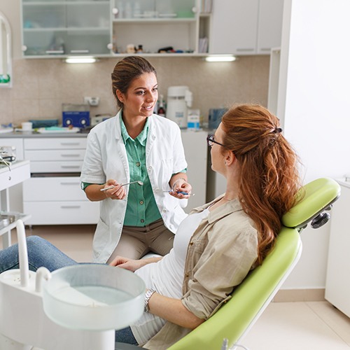 Dentist talking to patient in treatment room
