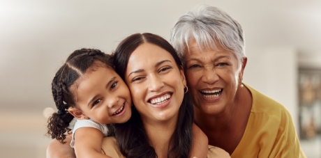 Three people sitting outside and smiling