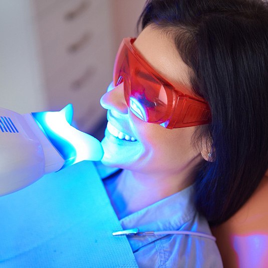Woman in dental chair having teeth whitened