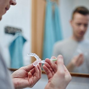 Man applying whitening gel to custom-fitted applicator