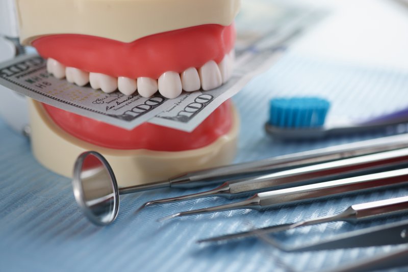 Model of a smile after cosmetic dentistry biting money